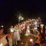 Newlyweds surrounded by guests holding sparklers at a wedding sendoff